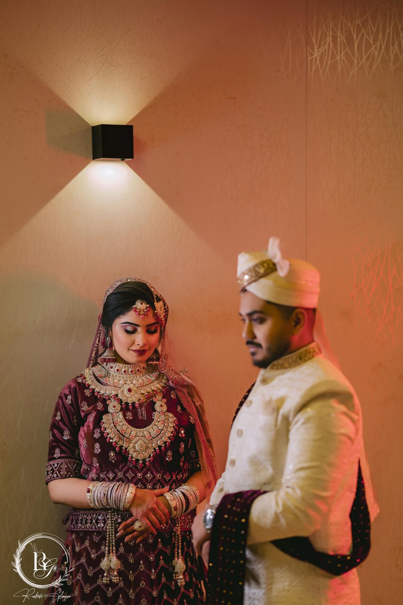 Bride and groom under warm wall light