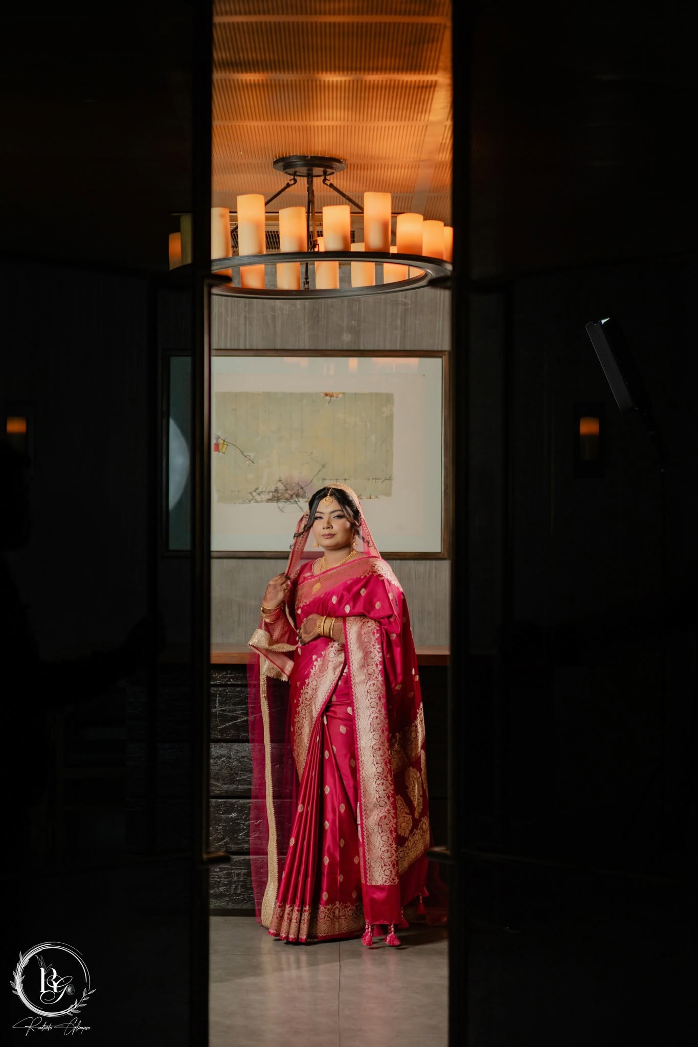 Bride framed in doorway with chandelier